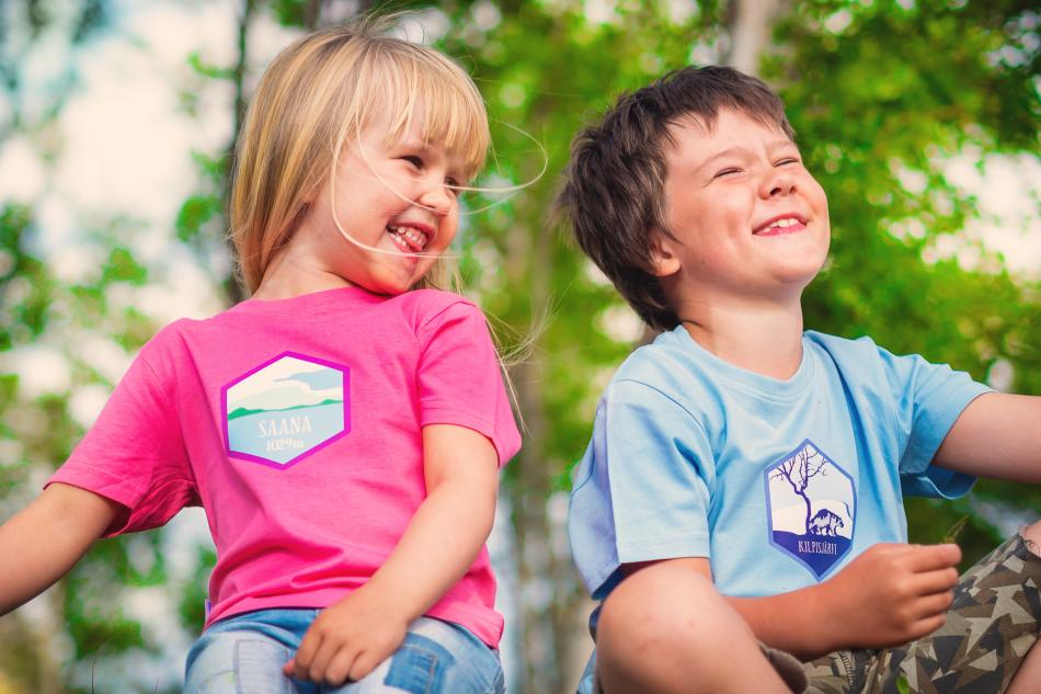 Kilpisjärvi themed pink and blue t-shirts on two smiling kids